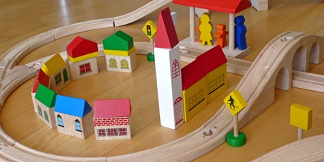 Spielzeug-Holz-Eisenbahn mit kleinem Dorf und Kirche.